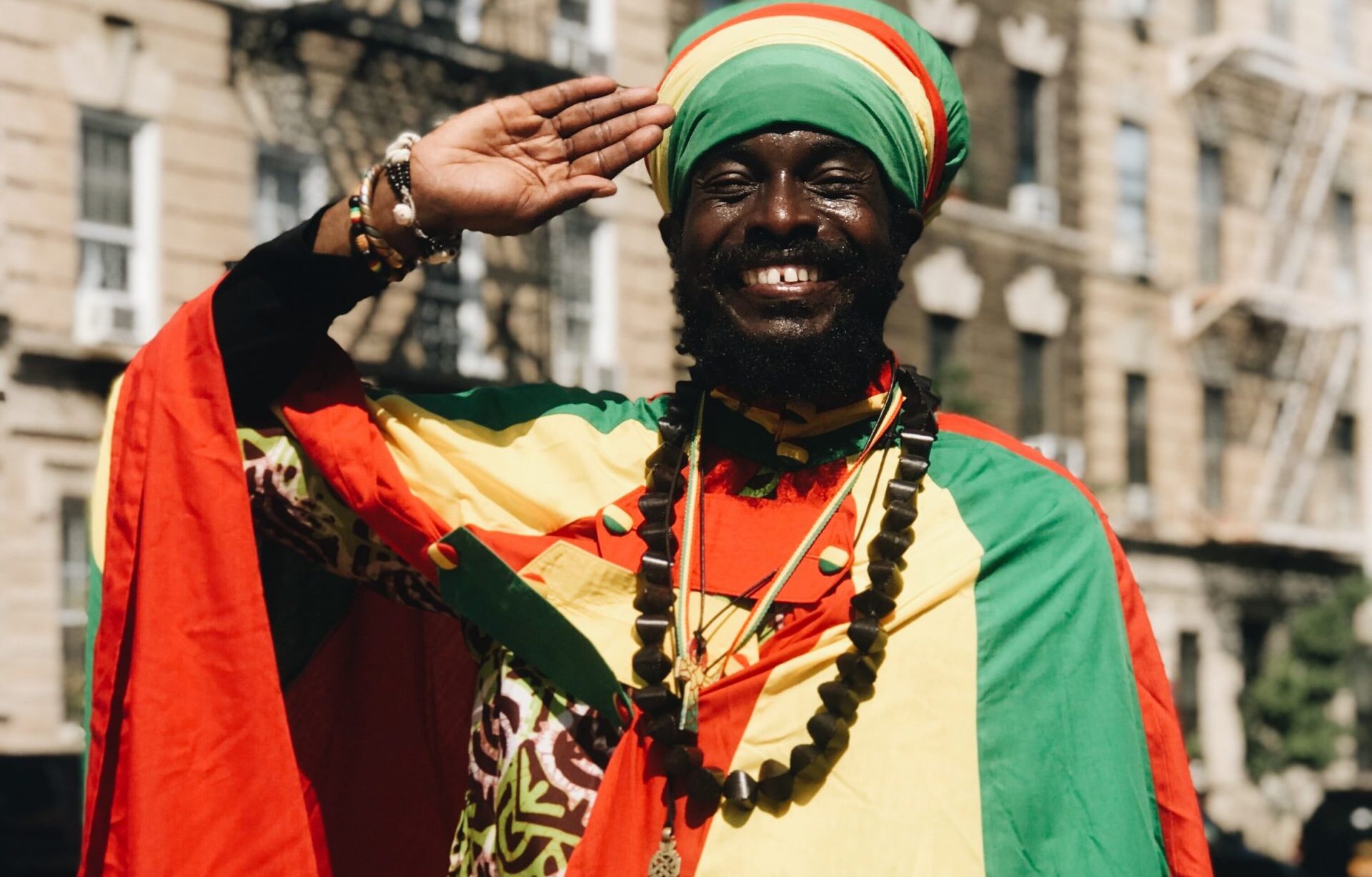 smiling man making hand salute